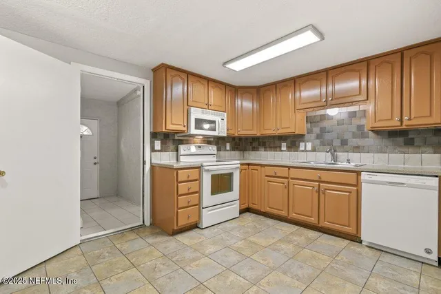 a kitchen with cabinets stove top oven and sink