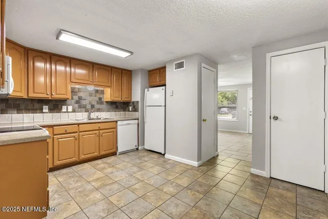 a kitchen with a refrigerator sink and cabinets