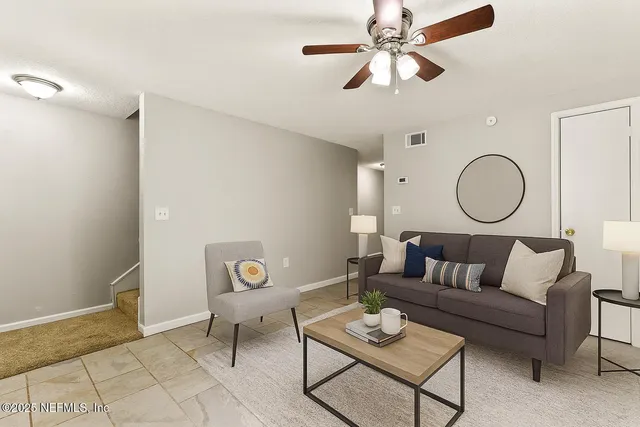 a living room with furniture and a mirror