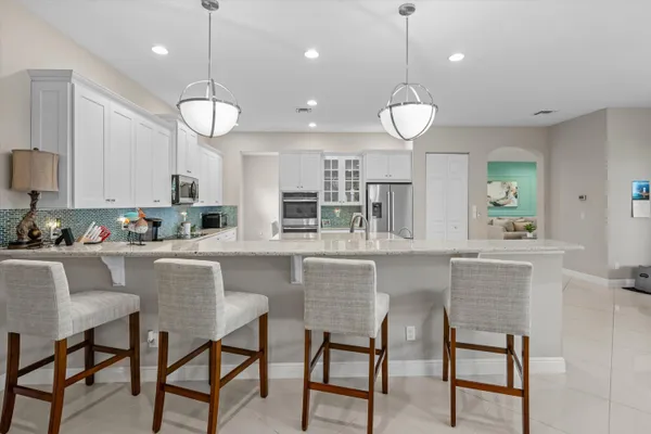 a kitchen with a dining table chairs and cabinets