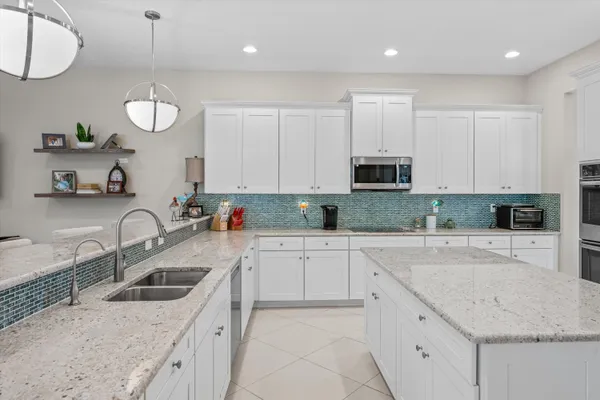 a kitchen with granite countertop a sink a stove and cabinets