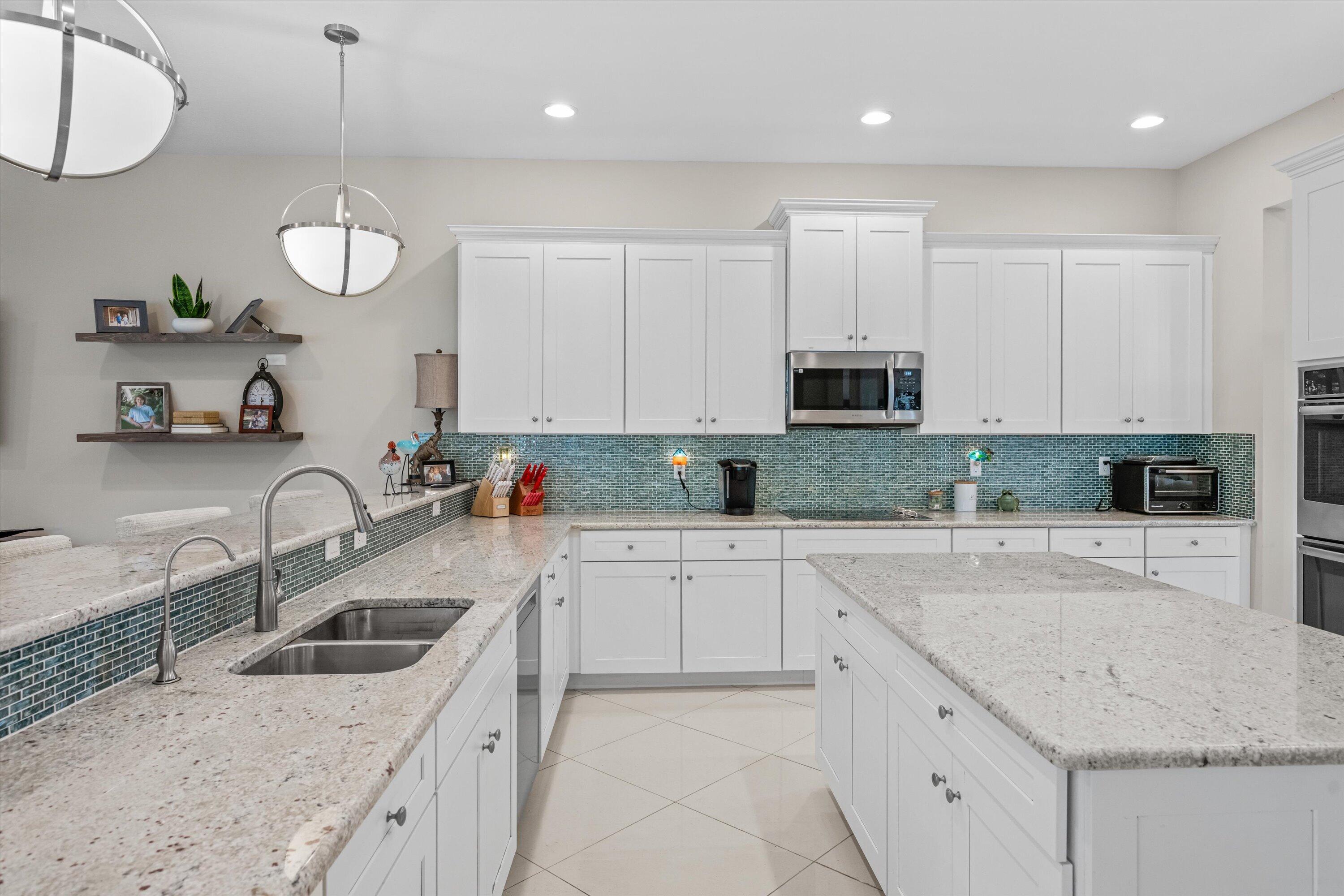 108 Casa Circle Jupiter, FL 33458 - Photo 14 of 53 a kitchen with granite countertop a sink a stove and cabinets