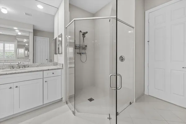 a bathroom with a shower sink and mirror