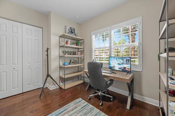 a bedroom with a bed lamps and windows