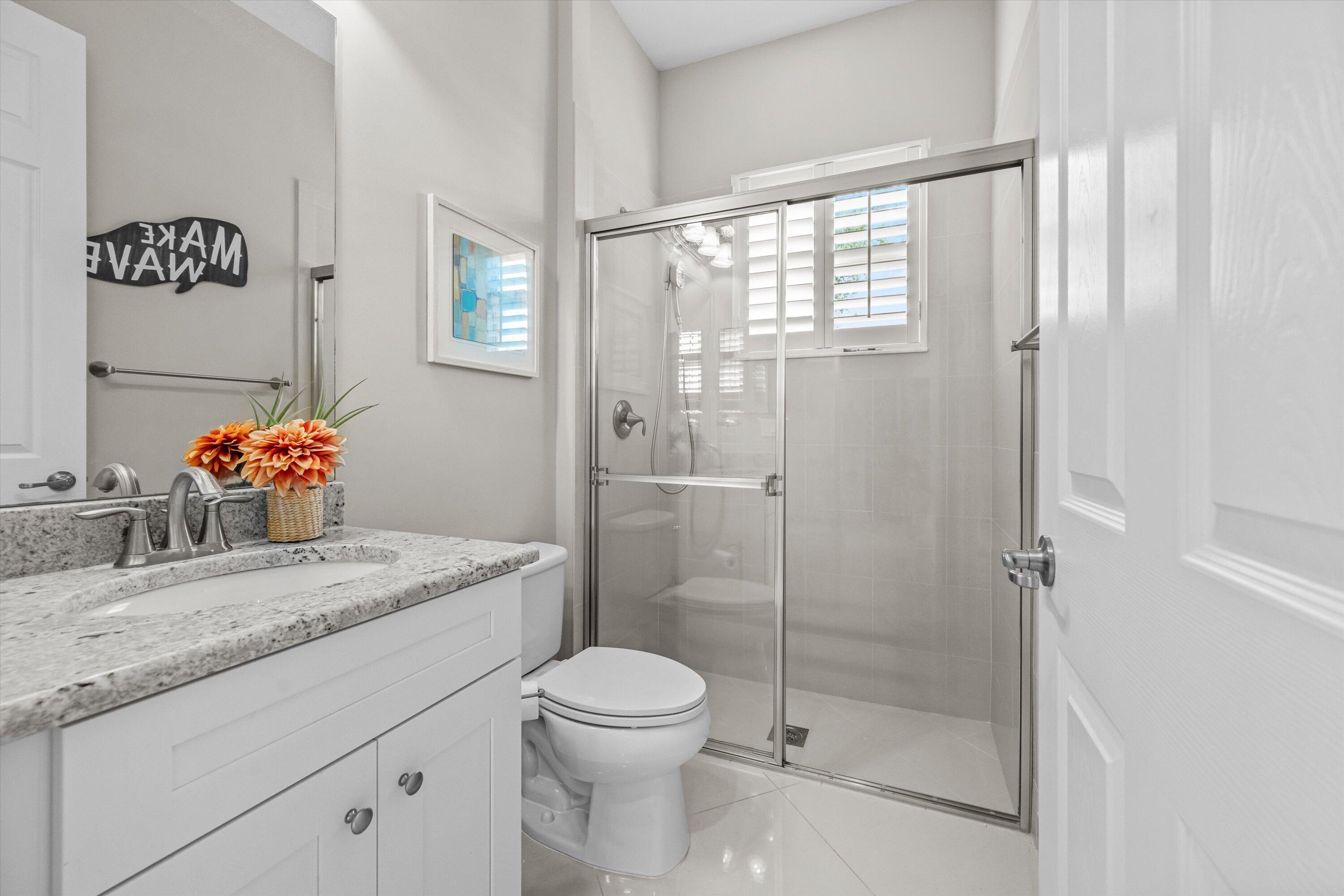 108 Casa Circle Jupiter, FL 33458 - Photo 31 of 53 a bathroom with a granite countertop sink a toilet and shower