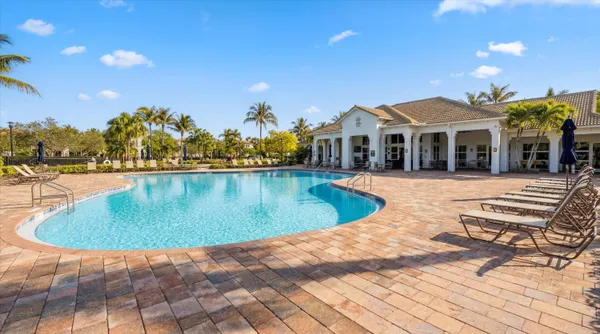 a view of swimming pool with outdoor seating and palm trees