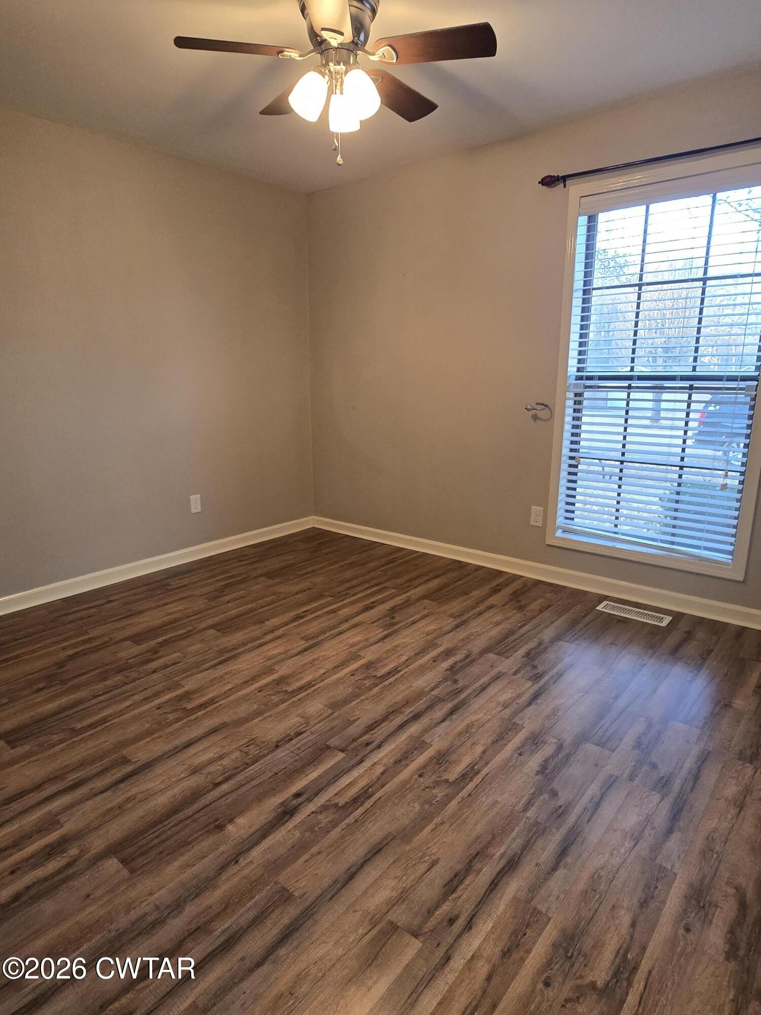 18 Lake Avenue Jackson, TN 38301 - Photo 13 of 19 an empty room with wooden floor chandelier fan and windows