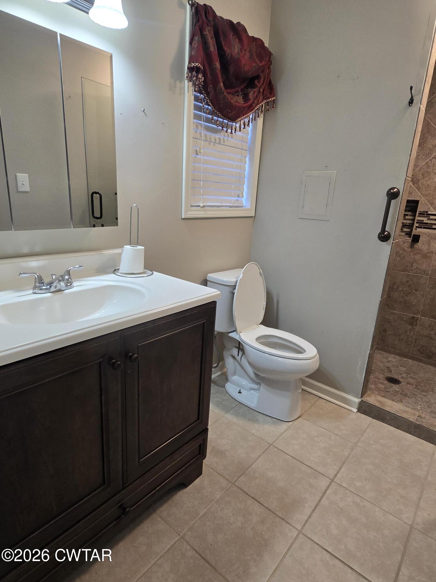 18 Lake Avenue Jackson, TN 38301 - Photo 17 of 19 a bathroom with a sink a toilet a mirror and vanity