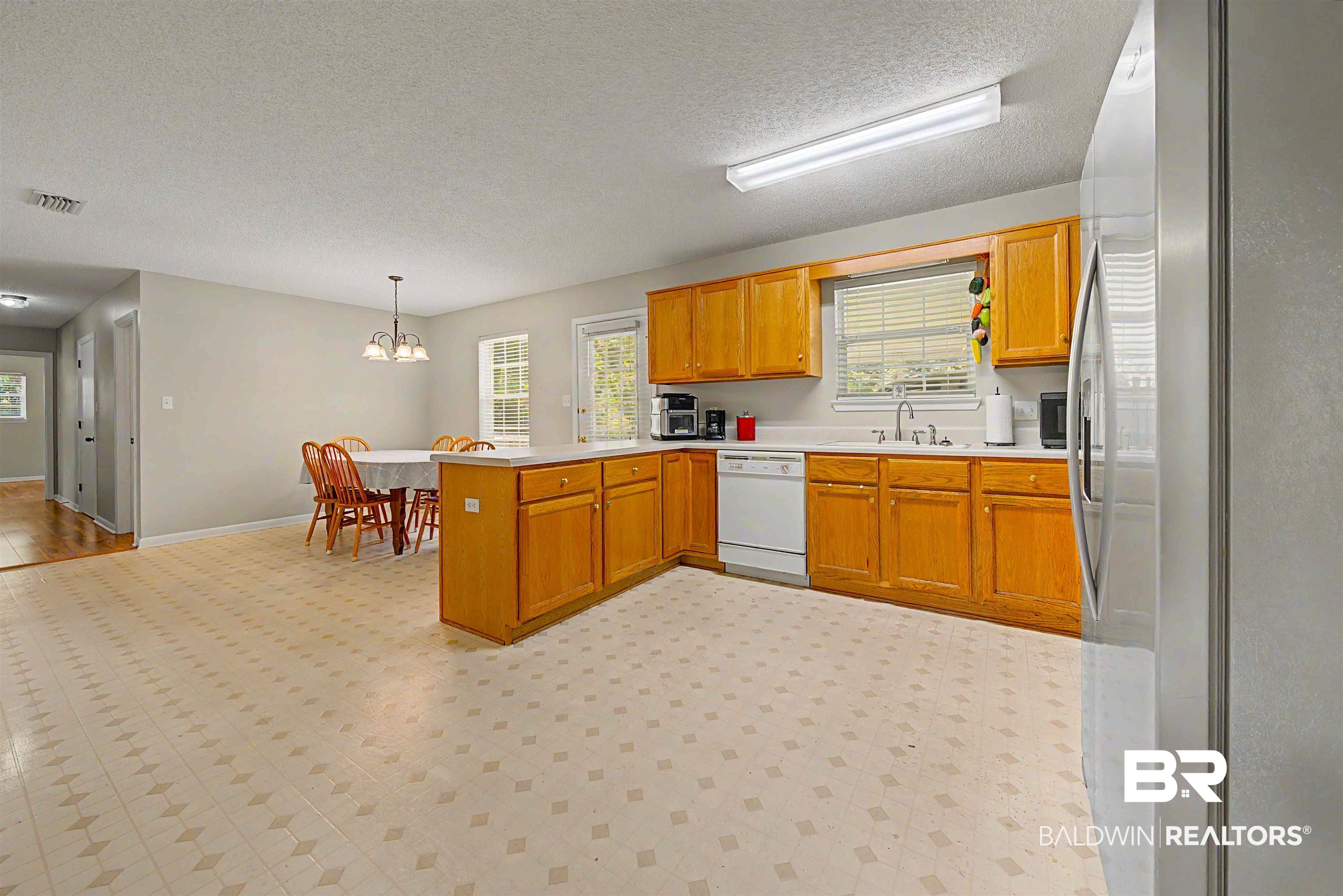 22963 Highway 98 Foley, AL 36535 - Photo 10 of 52 Spacious kitchen featuring wood-finish cabinetry, white countertops, a double basin sink, and white appliances