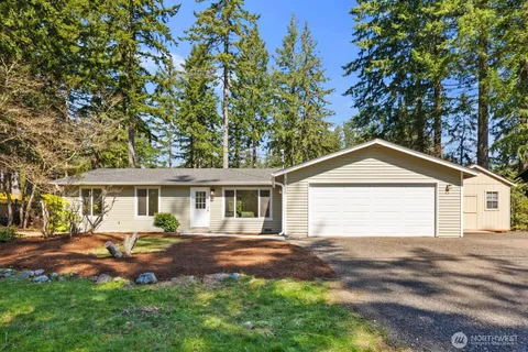 a front view of a house with a garden and trees