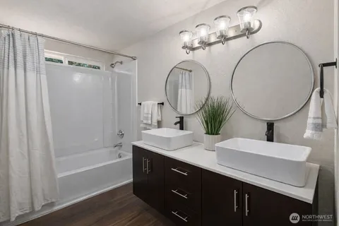 a bathroom with a double vanity sink mirror and shower