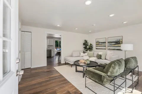 a living room with furniture and wooden floor