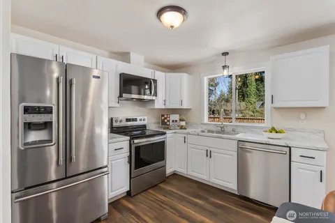 a kitchen with stainless steel appliances a refrigerator sink and microwave