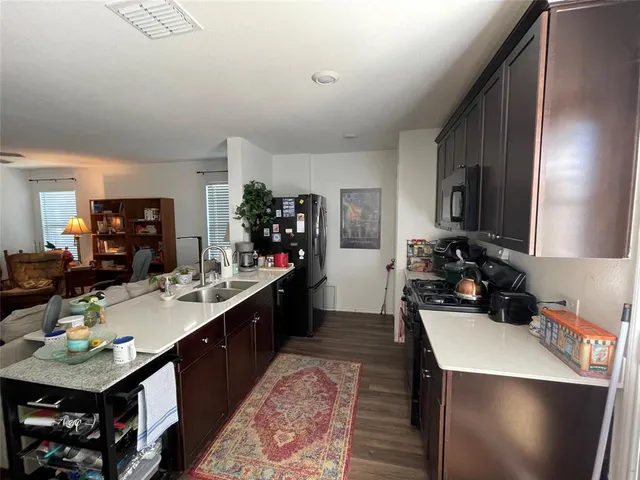 a kitchen with a sink a stove and chairs