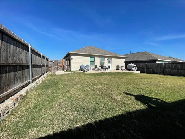 a view of a house with backyard and sitting area