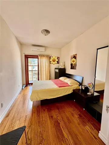 a spacious bedroom with a bed and wooden floor