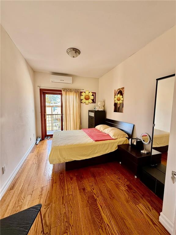 8752 18th Avenue, Unit 3E Brooklyn, NY 11214 - Photo 12 of 15 a spacious bedroom with a bed and wooden floor