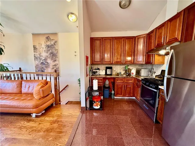 a kitchen with granite countertop a refrigerator and a stove top oven