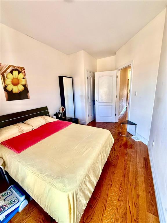 8752 18th Avenue, Unit 3E Brooklyn, NY 11214 - Photo 9 of 15 a bed sitting in a bedroom next to a window