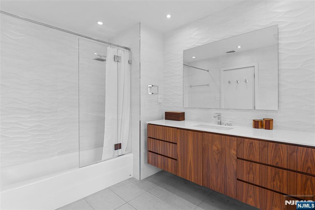 67 Forest Road Tenafly, NJ 07670 - Photo 22 of 42 a bathroom with a tub a sink shower and mirror