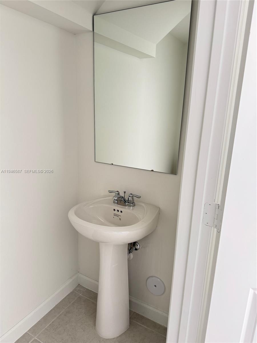 17953 Southwest 359th Street, Unit 17953 Homestead, FL 33034 - Photo 12 of 32 a bathroom with a sink a mirror and a toilet