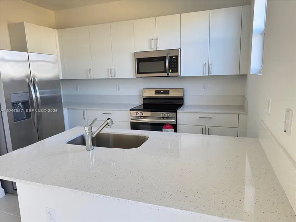 a kitchen with granite countertop a sink and a stove top oven