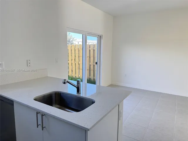 a kitchen with a sink a counter top space and cabinets