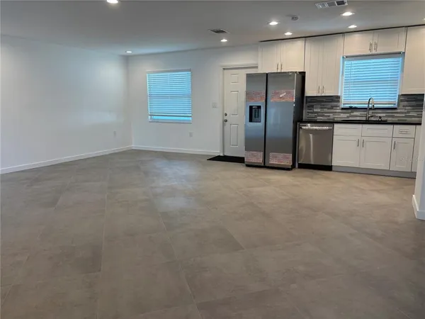 a kitchen with stainless steel appliances granite countertop a refrigerator and a stove top oven
