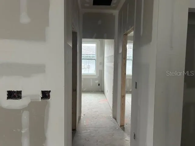 a view of a hallway with wooden floor and closet