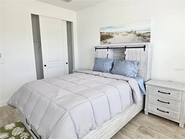 a bedroom with a bed and painting on the wall