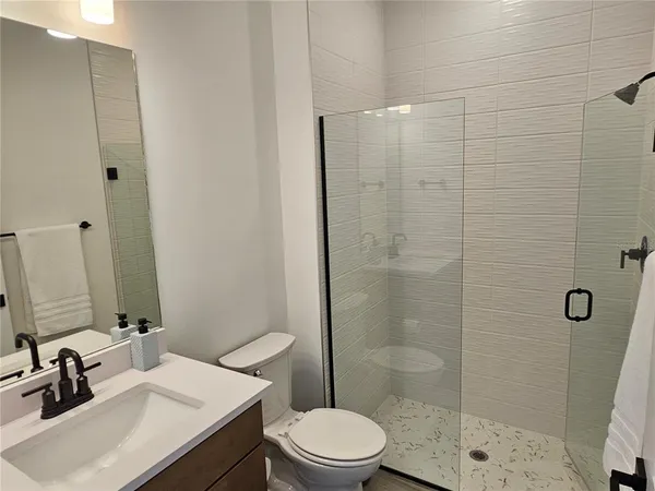 a bathroom with a sink a toilet and shower