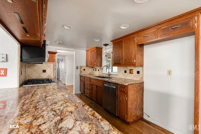 a kitchen with stainless steel appliances granite countertop a sink stove and refrigerator