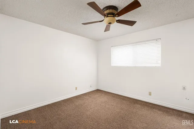 an empty room with a window and a fan