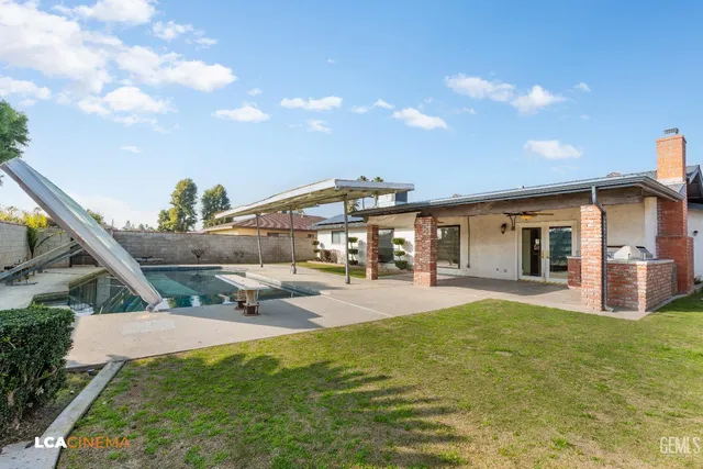 a view of a house with a big yard and a large tree