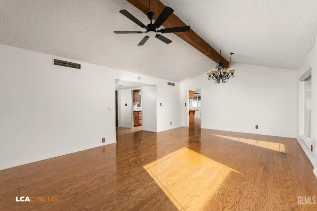 a view of a livingroom with wooden floor and a ceiling fan