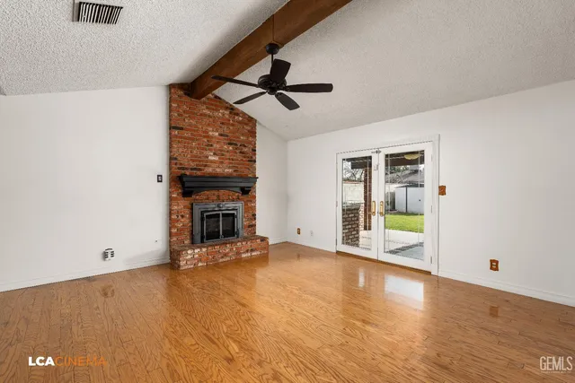a view of an empty room with a fireplace and a window