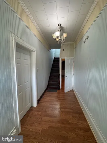 en view of a hallway with wooden floor and staircase