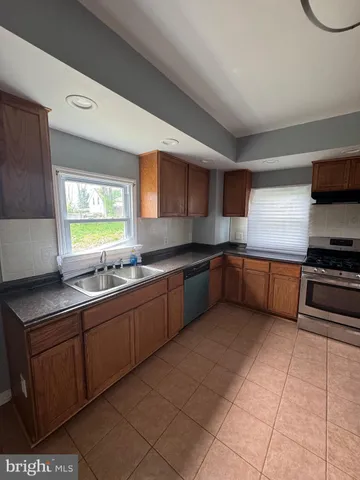 a kitchen with stainless steel appliances granite countertop a sink counter space cabinets and a large window