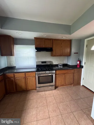 a kitchen with granite countertop a stove a sink and a microwave