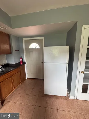 a kitchen with granite countertop a refrigerator and a sink