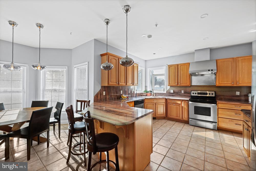 13710 Baden Naylor Road Upper Marlboro, MD 20772 - Photo 16 of 66 a kitchen with stainless steel appliances granite countertop a stove top oven a sink a dining table and chairs