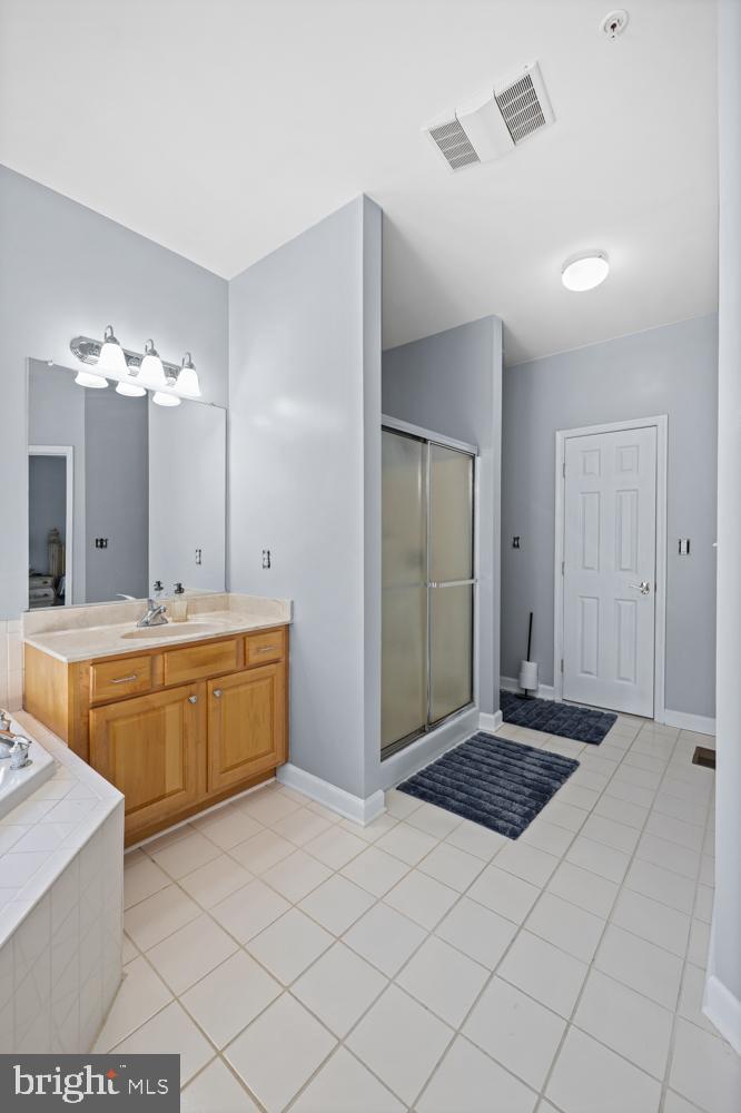 13710 Baden Naylor Road Upper Marlboro, MD 20772 - Photo 29 of 66 a spacious bathroom with a granite countertop sink a mirror and a bathtub