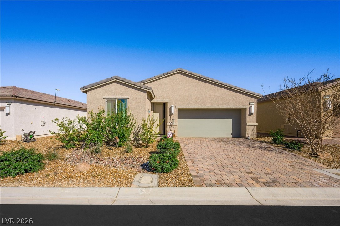 4743 South Springridge Street Pahrump, NV 89061 - Photo 2 of 50 Ranch-style house with a garage, decorative driveway, and stucco siding