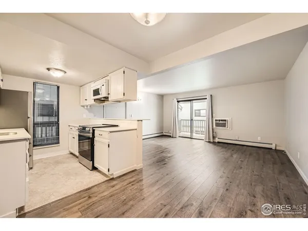a kitchen with a wooden floor and white appliances