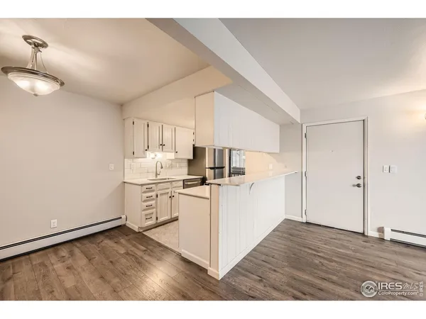 a kitchen with a sink cabinets and wooden floor