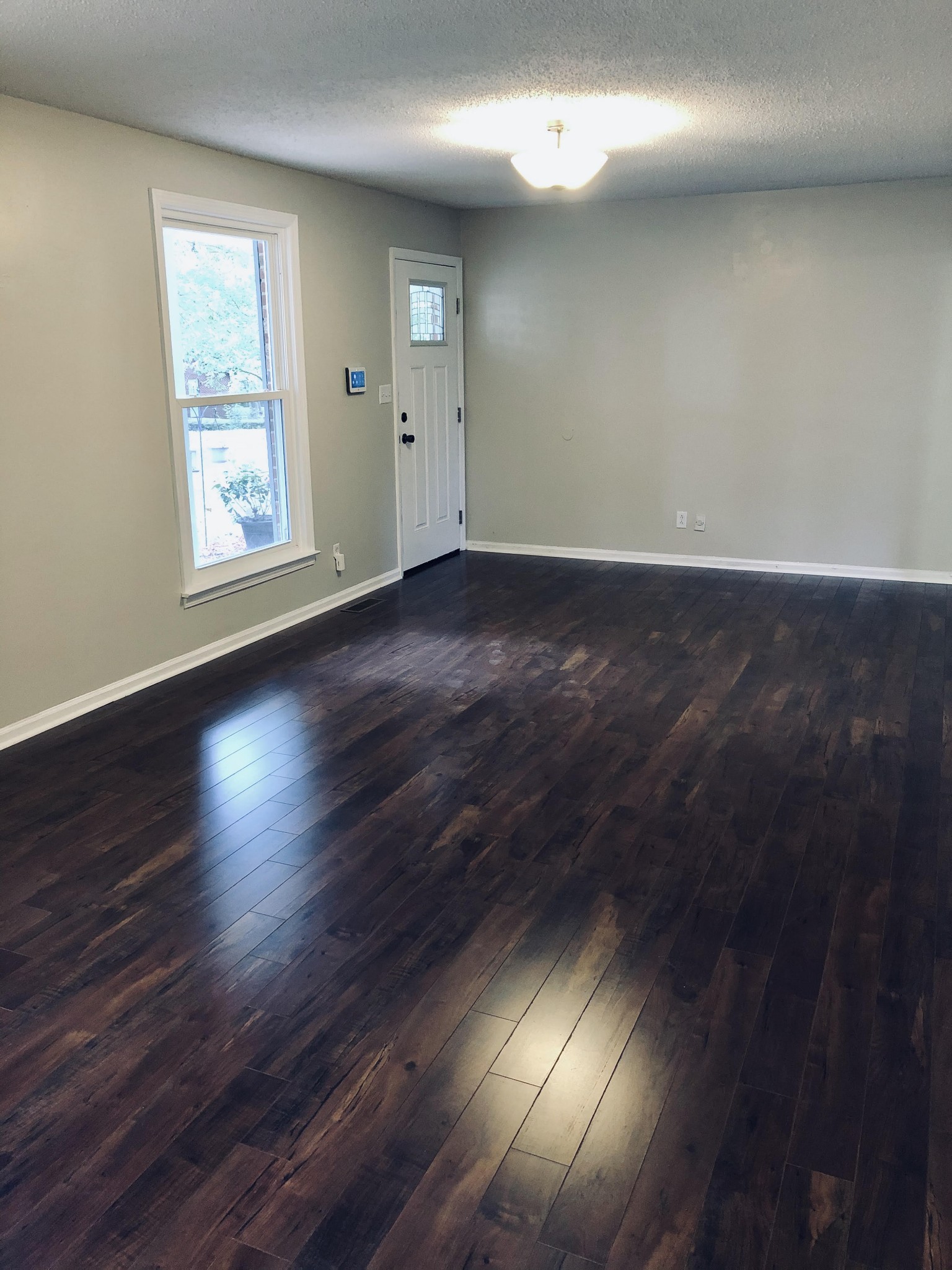 225 Yorktown Road Clarksville, TN 37042 - Photo 3 of 10 an empty room with wooden floor and windows