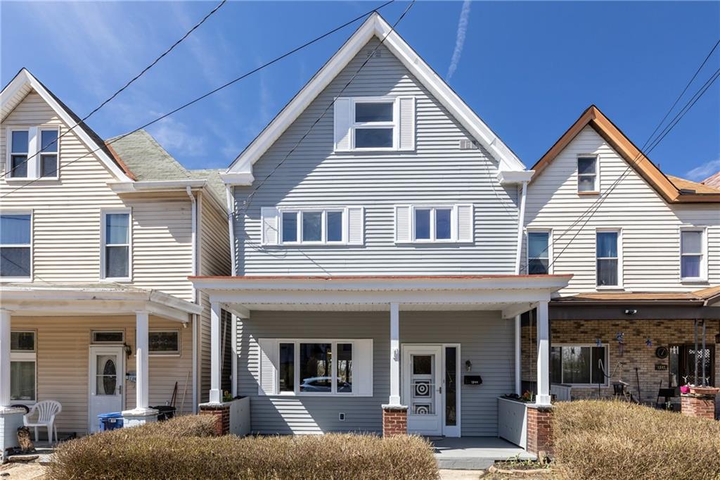 a view of a white house with large windows and a table