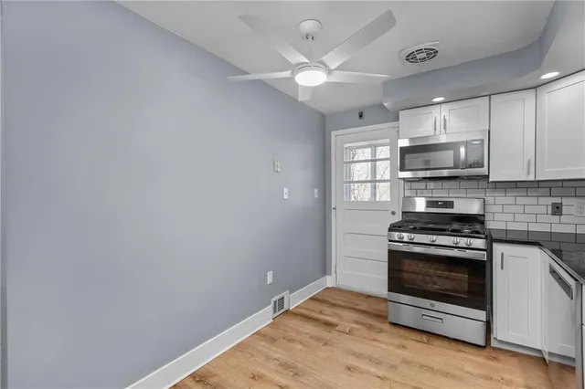 a kitchen with kitchen island a stove and a microwave