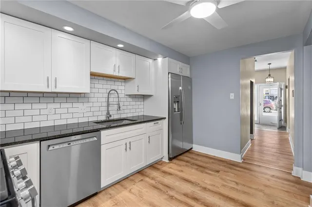 a kitchen with granite countertop a sink stainless steel appliances and cabinets