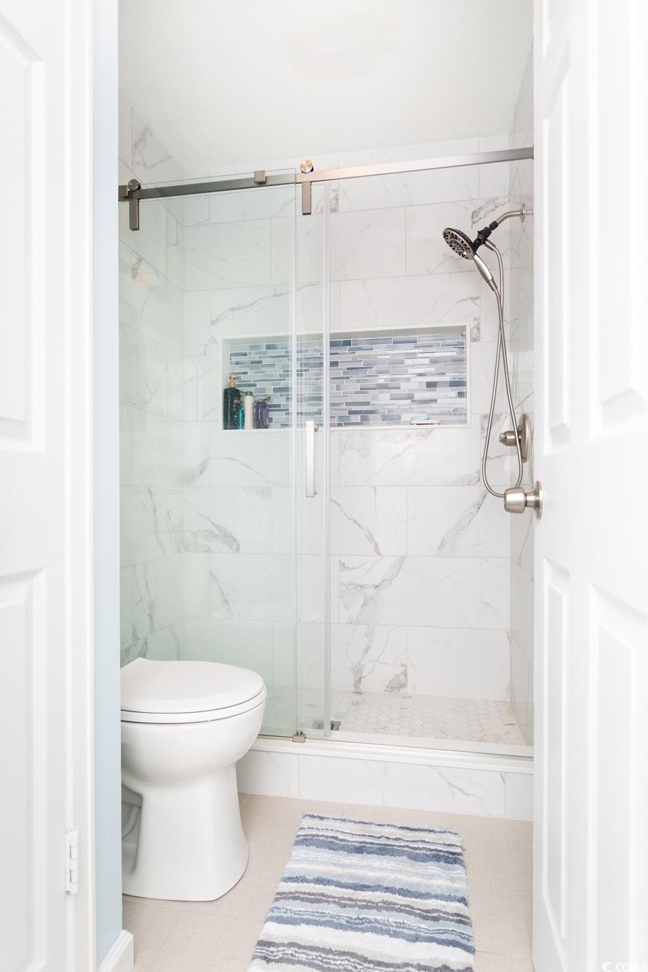 351 Lake Arrowhead Road, Unit 25404 Myrtle Beach, SC 29572 - Photo 15 of 37 Bathroom featuring walk in shower, tile patterned flooring, and toilet